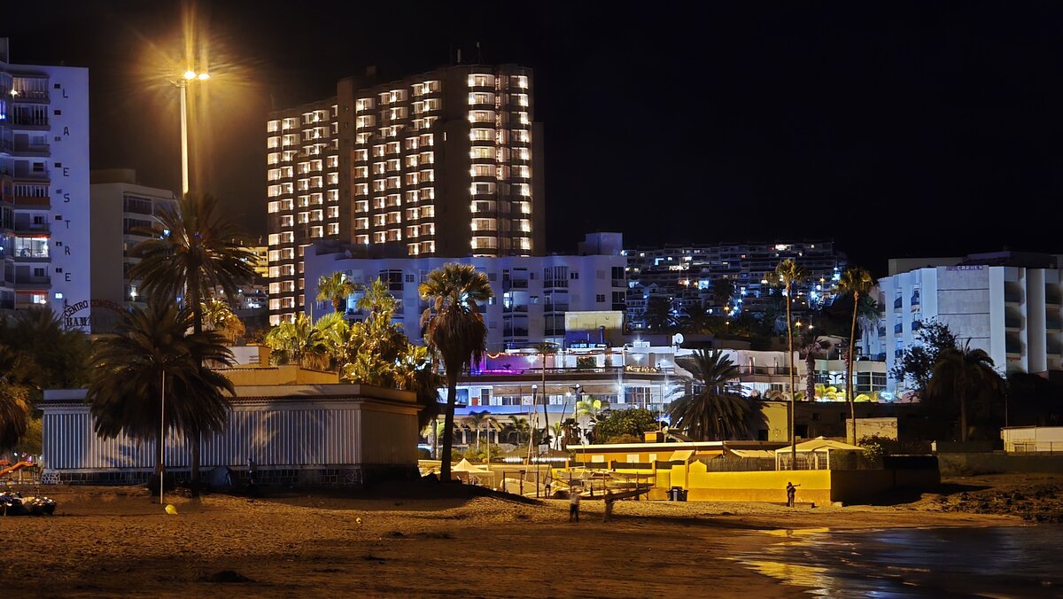 Los Cristianos na Teneryfie nocą – oświetlone hotele i fragment plaży.