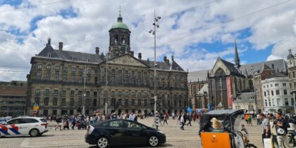 Turyści przed Pałacem Królewskim w Amsterdamie podczas wyjazdu z biurem podróży