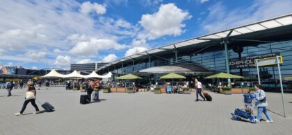 Pyton w biustonoszu na lotnisku Amsterdam-Schiphol. Pasażerowie przed terminalem lotniska.