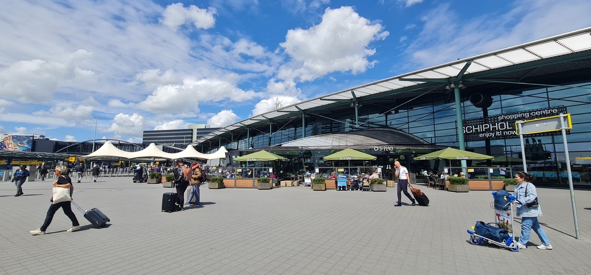 Pyton w biustonoszu na lotnisku Amsterdam-Schiphol. Pasażerowie przed terminalem lotniska.