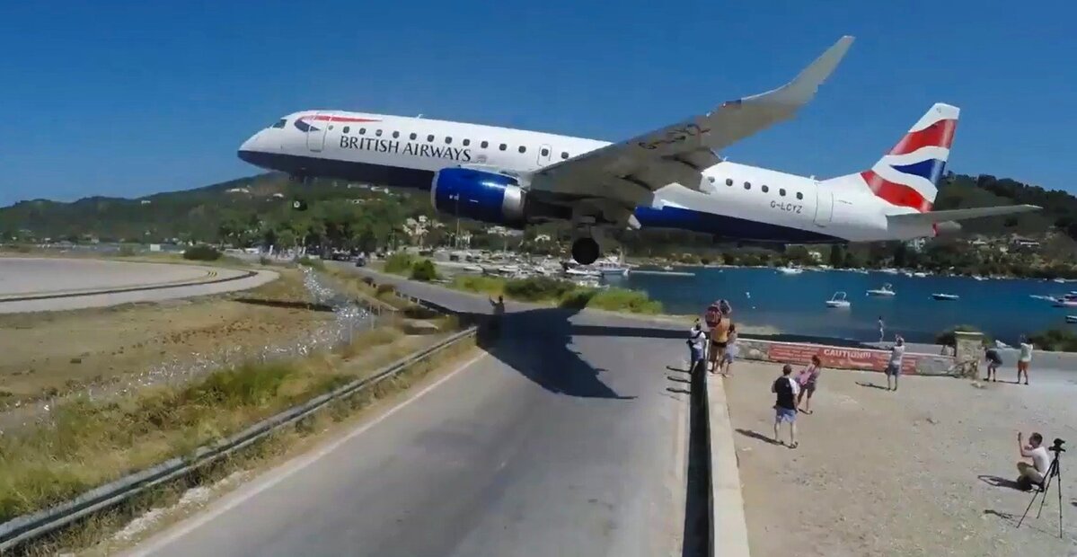 Lotnisko na Skiathos. Samolot lądujący na lotnisku na Skiathos nad drogą i filmującymi go turystami