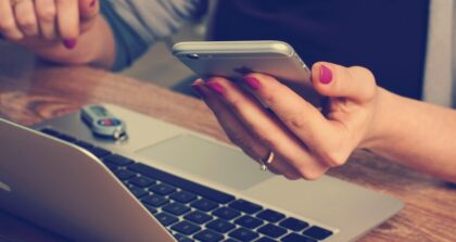 Oszustwa przy rezerwacji noclegu – kobieta korzystająca z laptopa i telefonu