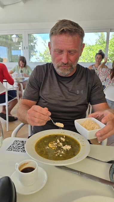 Marek Dąbrowski posypuje gofio zupę potaje de berros w restauracji na La Gomerze