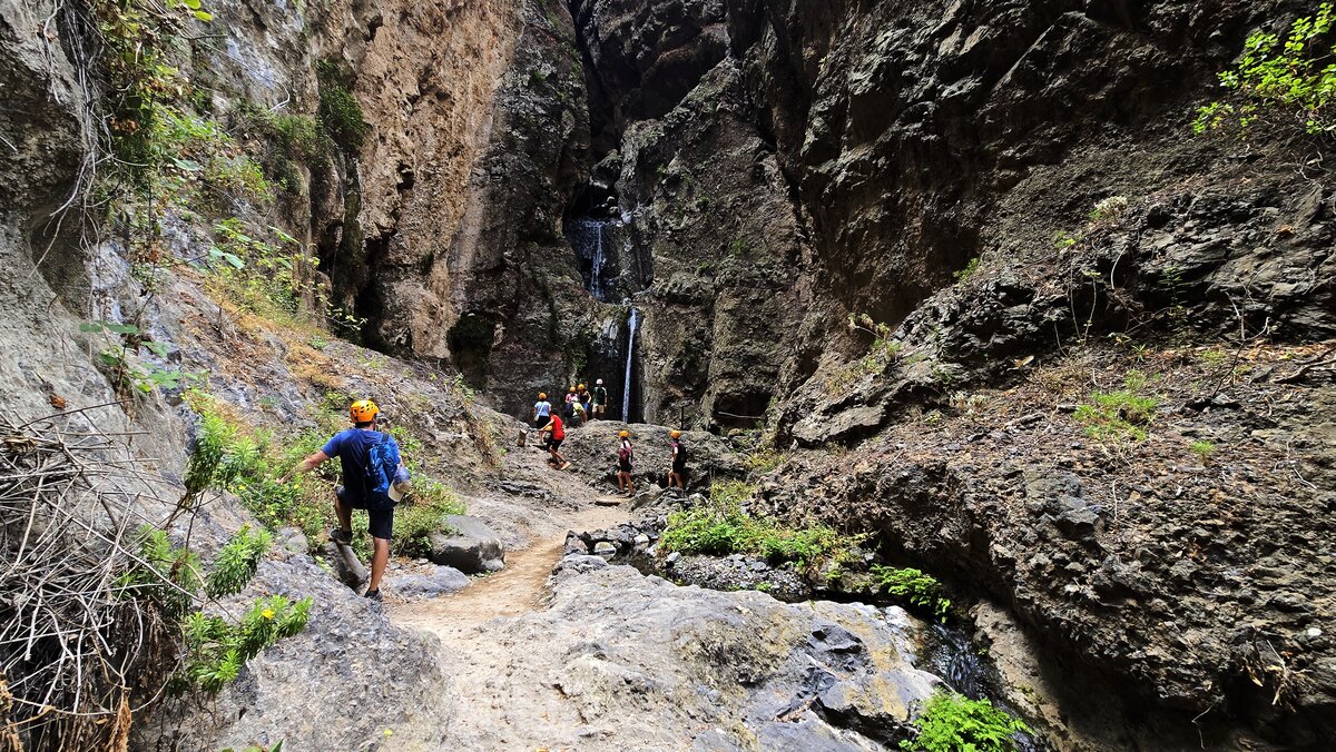 Wodospad Barranco del Infierno – turyści oglądają kaskadę wody na końcu szlaku przez Piekielny Wąwóz na Teneryfie.