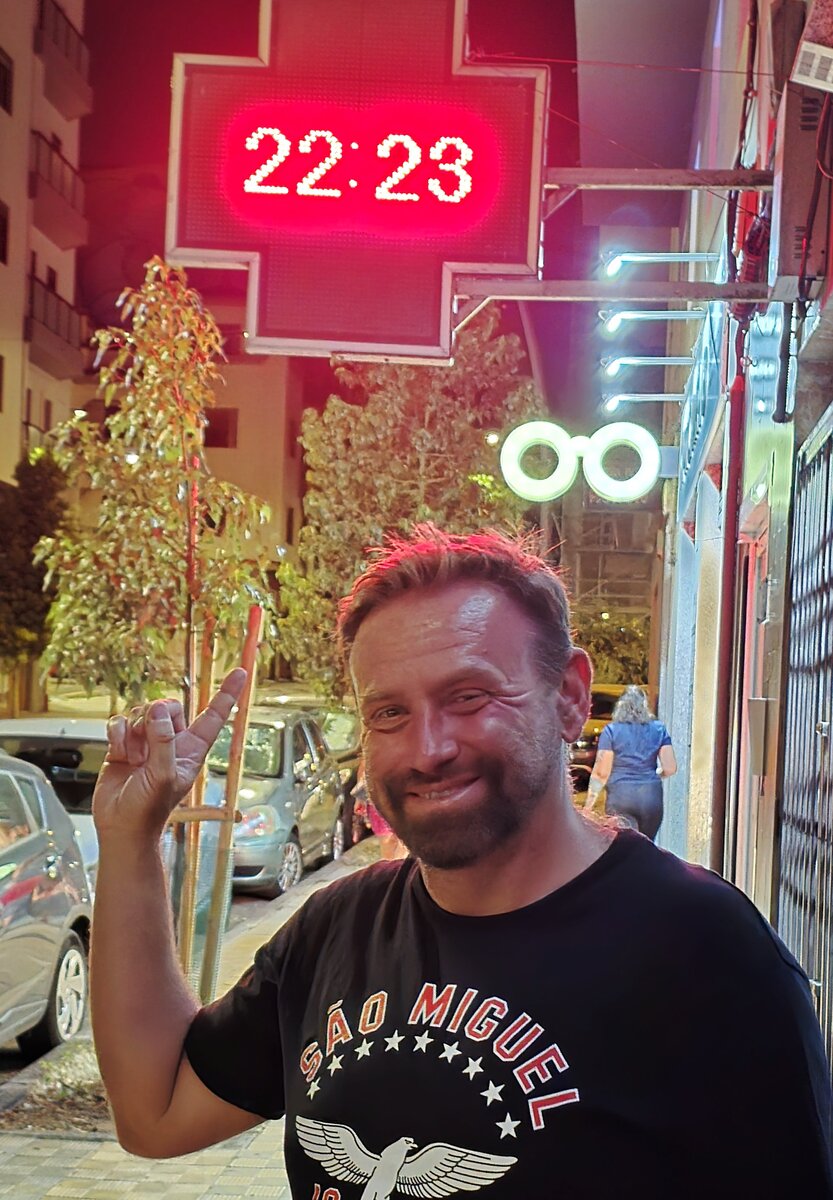Upały na Teneryfie – Marek Dąbrowski wskazuje zegar pokazujący godzinę 22:23 w Santa Cruz de Tenerife.